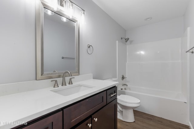 full bathroom featuring vanity, washtub / shower combination, wood finished floors, and toilet
