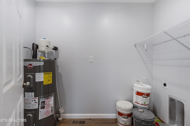 washroom with laundry area, visible vents, wood finished floors, electric dryer hookup, and water heater