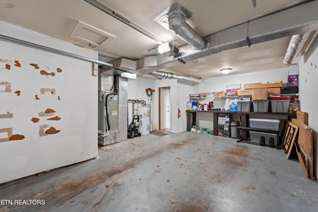 garage featuring a garage door opener, heating unit, and water heater