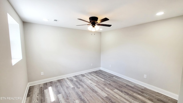 unfurnished room with a ceiling fan, baseboards, recessed lighting, wood finished floors, and visible vents