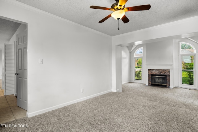 unfurnished living room with carpet floors, a premium fireplace, a textured ceiling, and ceiling fan