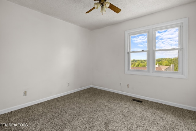 spare room featuring ceiling fan, a textured ceiling, visible vents, baseboards, and carpet flooring