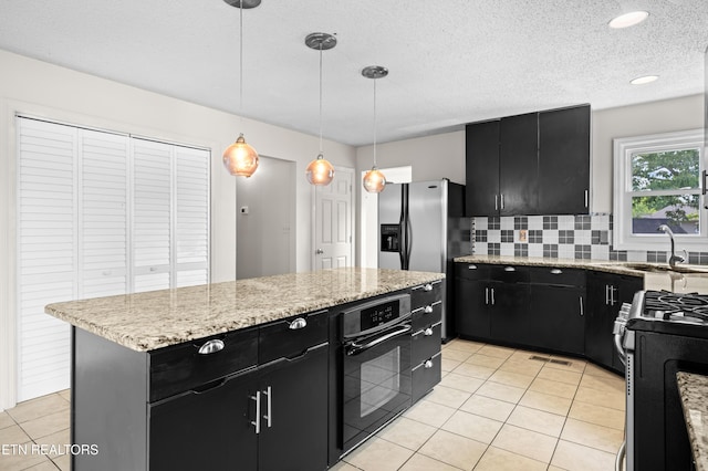 kitchen featuring dark cabinetry, black oven, light tile patterned flooring, and backsplash