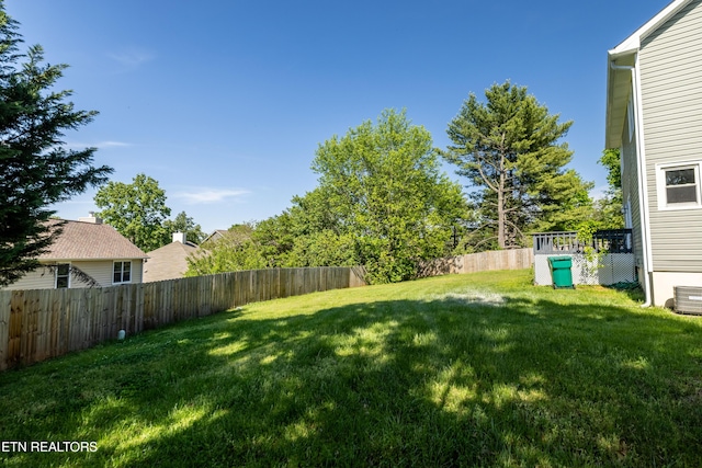 view of yard with a fenced backyard and central air condition unit