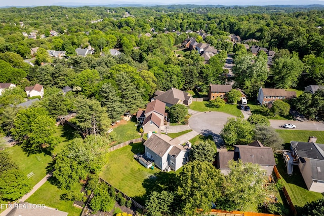 drone / aerial view featuring a view of trees and a residential view