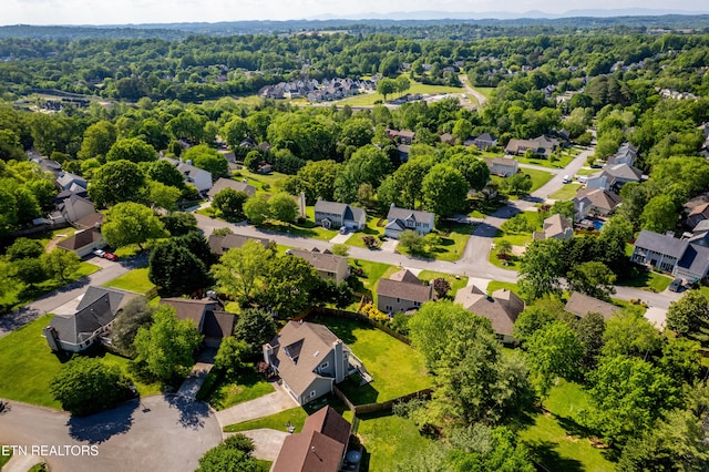 drone / aerial view featuring a wooded view and a residential view
