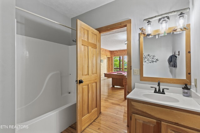 ensuite bathroom featuring bathtub / shower combination, vanity, hardwood / wood-style floors, billiards, and ensuite bathroom