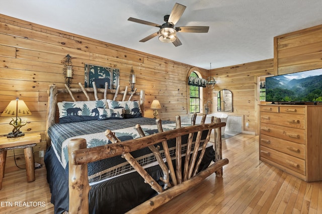 bedroom featuring wood walls and light wood-style flooring
