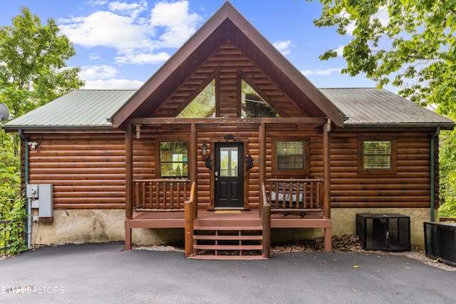 back of property featuring central air condition unit, metal roof, and a porch