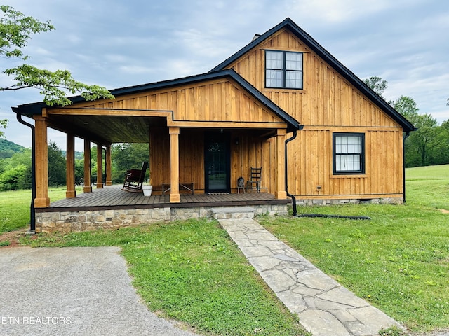 view of front of home with covered porch and a front lawn