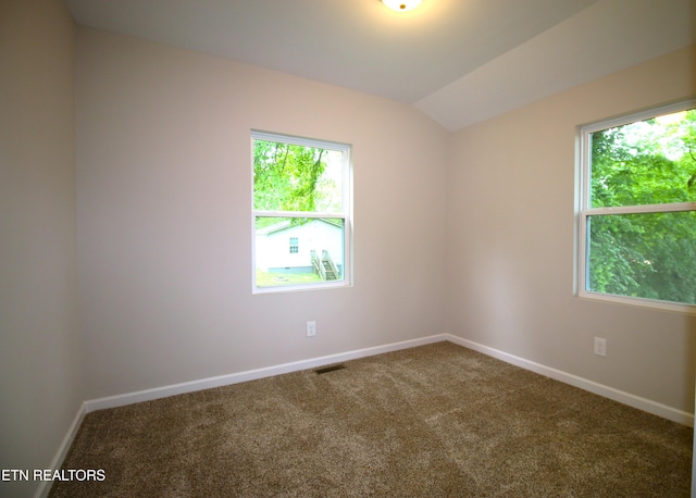 unfurnished room featuring carpet floors, baseboards, visible vents, and lofted ceiling
