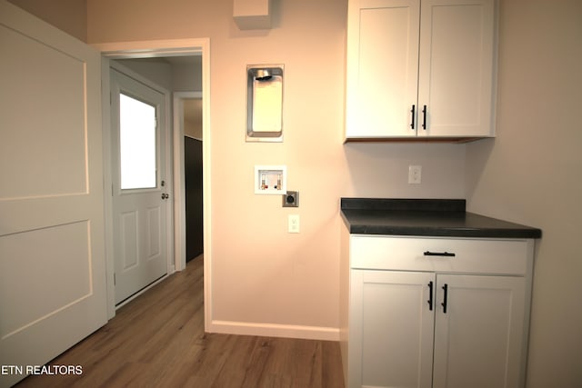 laundry area featuring washer hookup, hookup for an electric dryer, cabinet space, wood finished floors, and baseboards