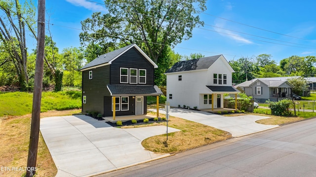 view of front of home with concrete driveway, a porch, and a shingled roof