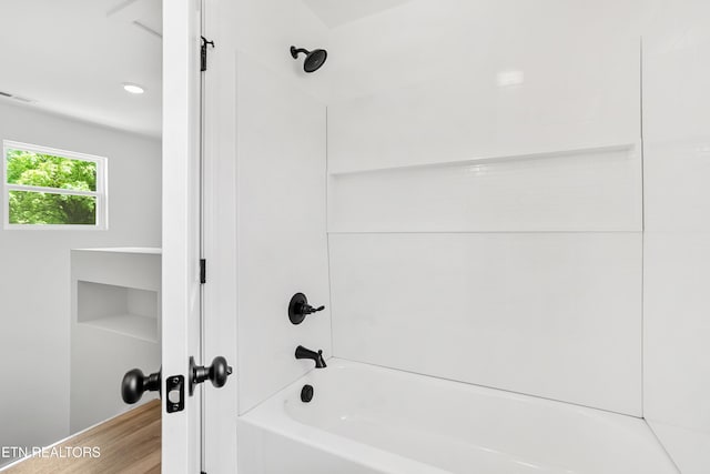 bathroom with shower / bath combination, visible vents, and wood finished floors