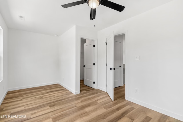 unfurnished bedroom featuring baseboards, ceiling fan, light wood-style floors, and visible vents
