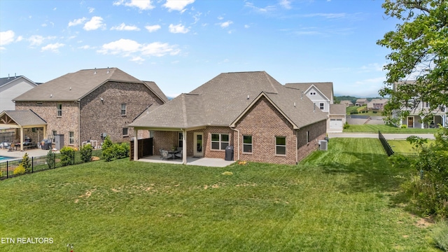 rear view of property featuring a yard, fence, a patio, and brick siding