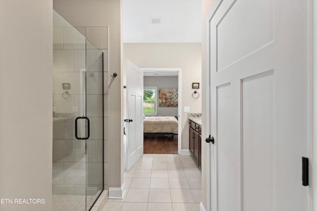 ensuite bathroom with a stall shower, baseboards, tile patterned floors, and connected bathroom