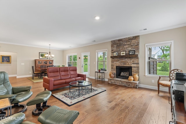 living room featuring a notable chandelier, light wood-style flooring, and crown molding