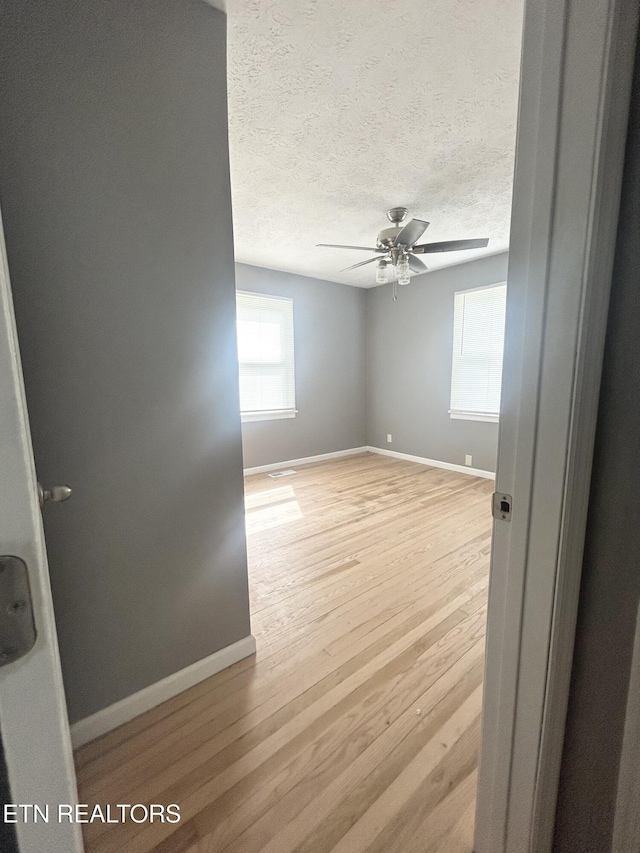 526 S Castle St, Knoxville, TN 37914 - unfurnished room featuring a ceiling fan, baseboards, light wood finished floors, and a textured ceiling