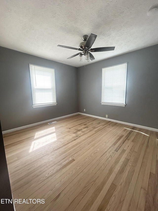 526 S Castle St, Knoxville, TN 37914 - unfurnished room featuring baseboards, a textured ceiling, ceiling fan, and light wood-style flooring