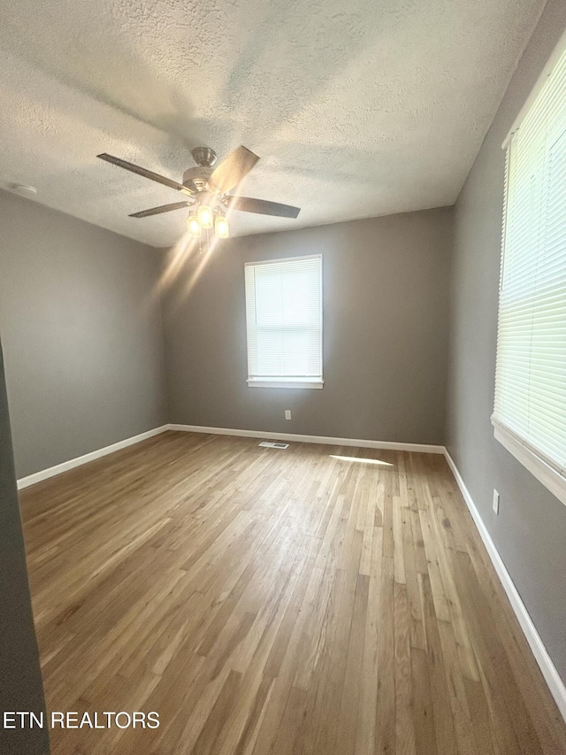 526 S Castle St, Knoxville, TN 37914 - additional living space featuring visible vents, wood finished floors, baseboards, ceiling fan, and a textured ceiling