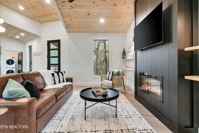 - Chinquapin Drive, Sevierville, TN 37876 - living area featuring a fireplace, wood ceiling, light wood finished floors, stacked washer / drying machine, and vaulted ceiling