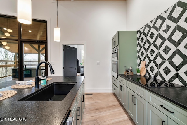 - Chinquapin Drive, Sevierville, TN 37876 - kitchen featuring a high ceiling, black electric stovetop, a sink, baseboards, and light wood-type flooring