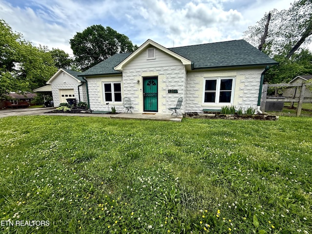 view of front facade featuring an attached garage, a shingled roof, and a front lawn