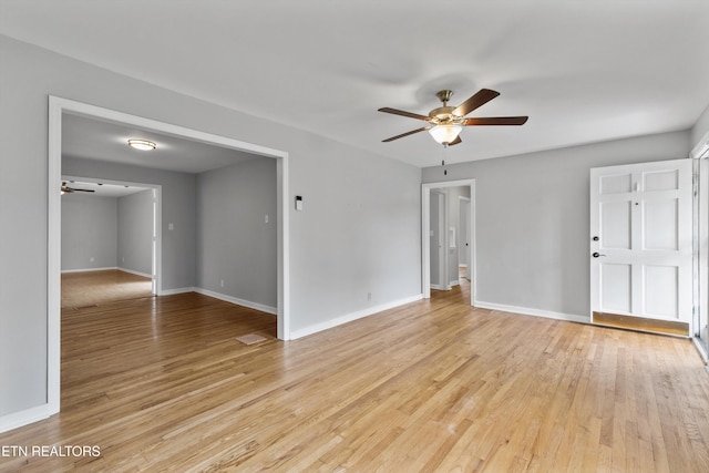 unfurnished room with baseboards, light wood-type flooring, and ceiling fan