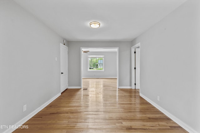 interior space with baseboards, light wood finished floors, and visible vents