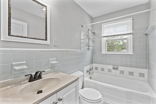 bathroom with tile walls, toilet, shower / bathing tub combination, and vanity