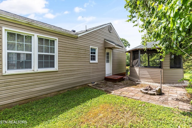rear view of property featuring a yard and a patio area