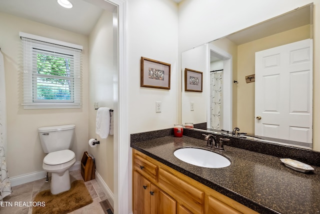 full bathroom with toilet, vanity, baseboards, and tile patterned floors