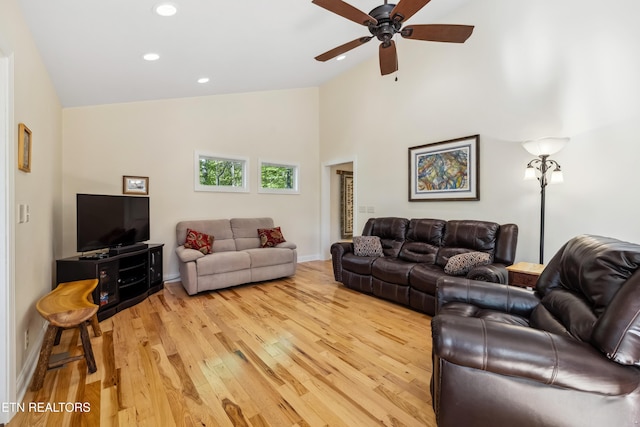 living area with light wood-style floors, a ceiling fan, recessed lighting, high vaulted ceiling, and baseboards