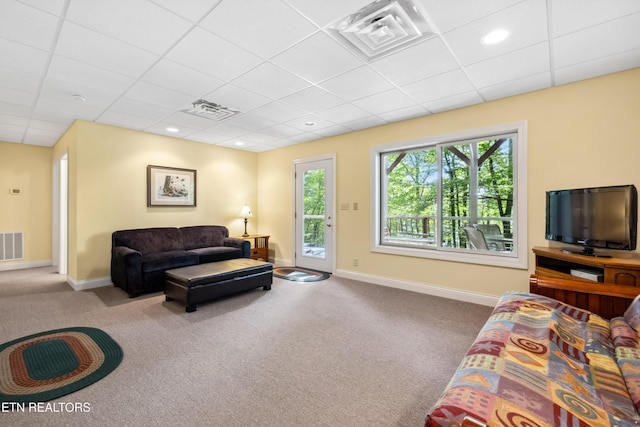 living room with a paneled ceiling, carpet floors, and baseboards