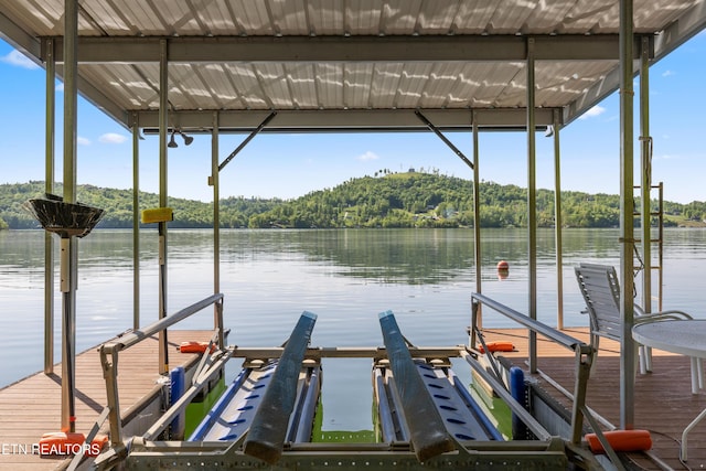 dock area with a water view, a forest view, and boat lift