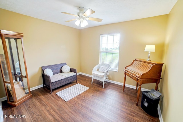 living area featuring wood finished floors, ceiling fan, and baseboards