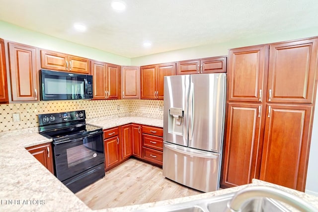 kitchen with black appliances, light countertops, light wood-type flooring, backsplash, and recessed lighting