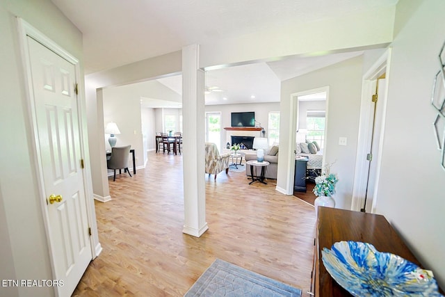 entrance foyer featuring ceiling fan, light wood-style floors, a fireplace, and baseboards