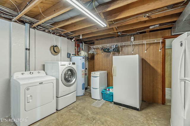 laundry room with water heater, separate washer and dryer, laundry area, and wood walls