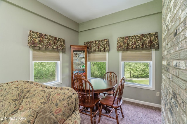 carpeted dining area featuring baseboards