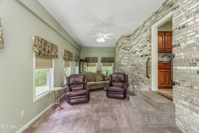 living area with a ceiling fan, carpet, lofted ceiling, and a healthy amount of sunlight