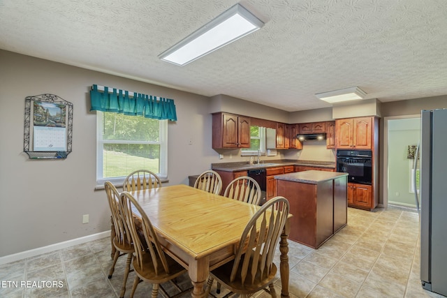 dining space with baseboards, light tile patterned flooring, and a textured ceiling