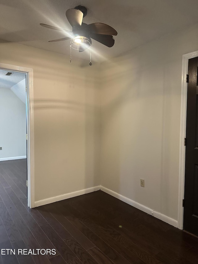 spare room with baseboards, a ceiling fan, dark wood finished floors, and visible vents