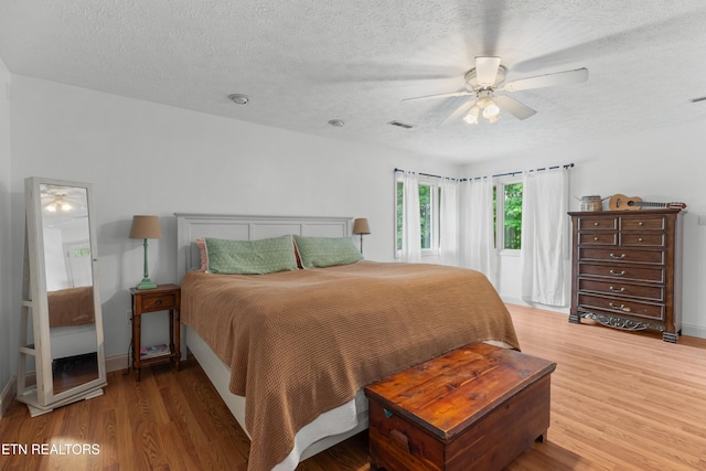 1819 Big Buck Ln, Sevierville, TN 37876 - bedroom featuring light wood-style floors, a textured ceiling, ceiling fan, and baseboards