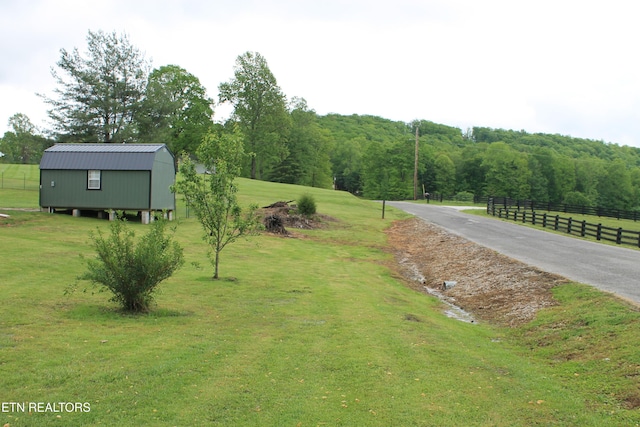 view of yard featuring an outdoor structure and fence