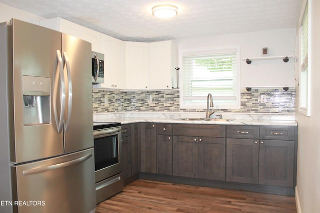 kitchen with white cabinetry, appliances with stainless steel finishes, dark wood-style floors, and a sink