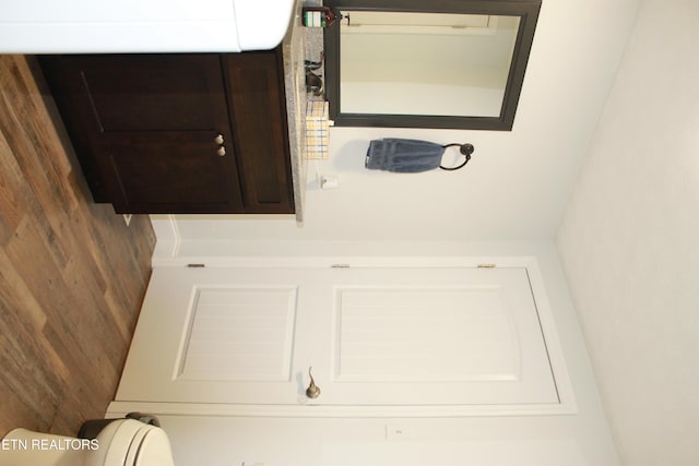 bathroom with wood walls and toilet