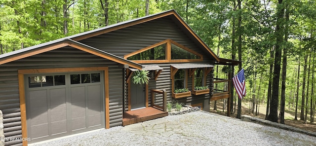 2165 Street Place Loop, Monterey, TN 38574 - view of front of home featuring driveway, a garage, a forest view, and faux log siding
