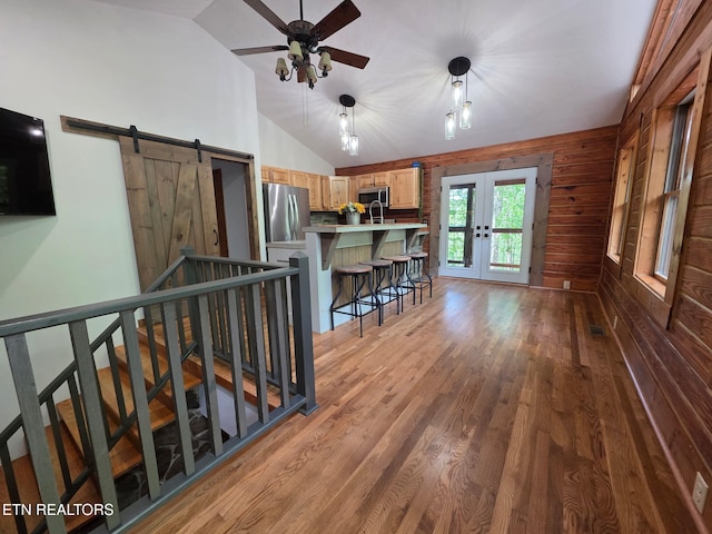 2165 Street Place Loop, Monterey, TN 38574 - living room with vaulted ceiling, french doors, ceiling fan, a barn door, and wooden walls
